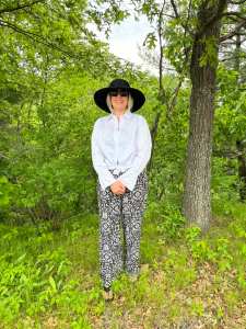 Georgia Lee Arts standing in woods with hat on